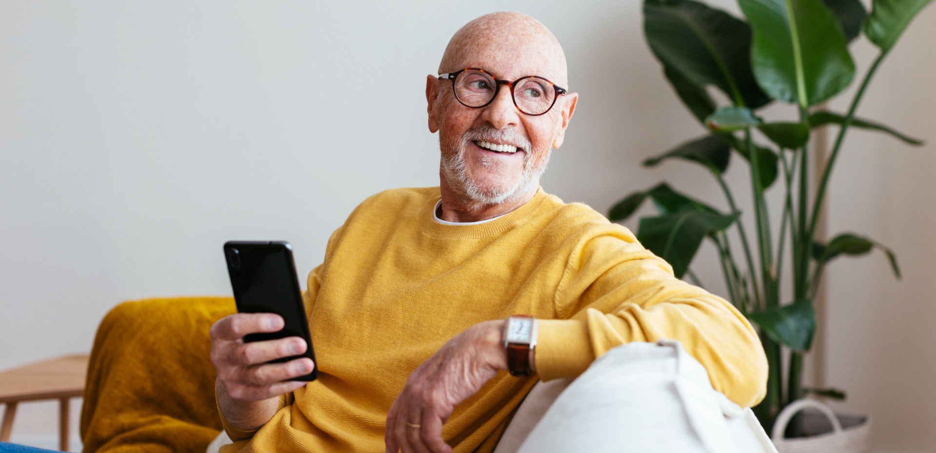 Älterer Mann sitzend mit Smartphone in der Hand